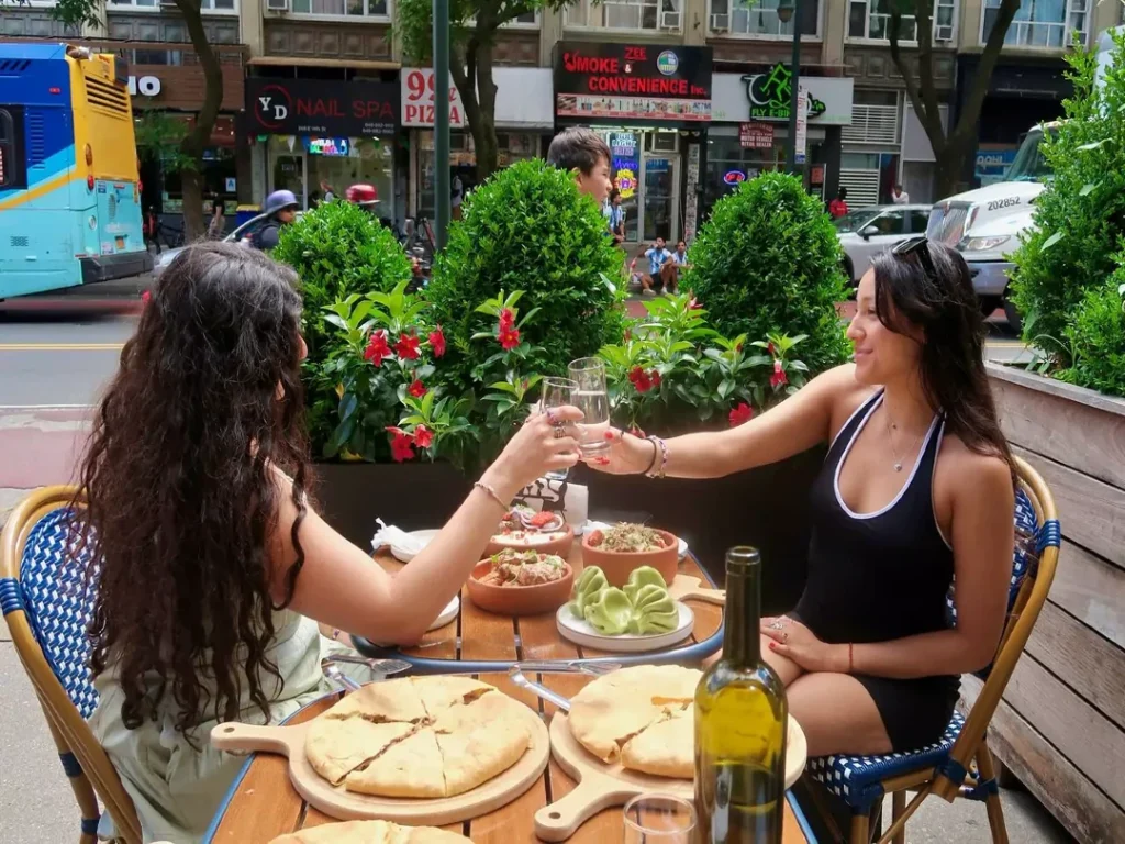 two girls toasting wine on the outdoor patio of Speravi NYC on 14th st